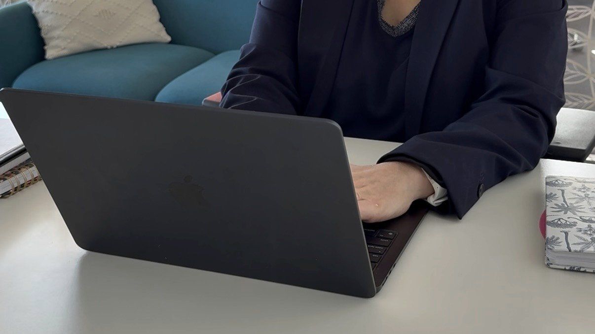 Mains sur le clavier d’un ordinateur portable, dans un espace de travail