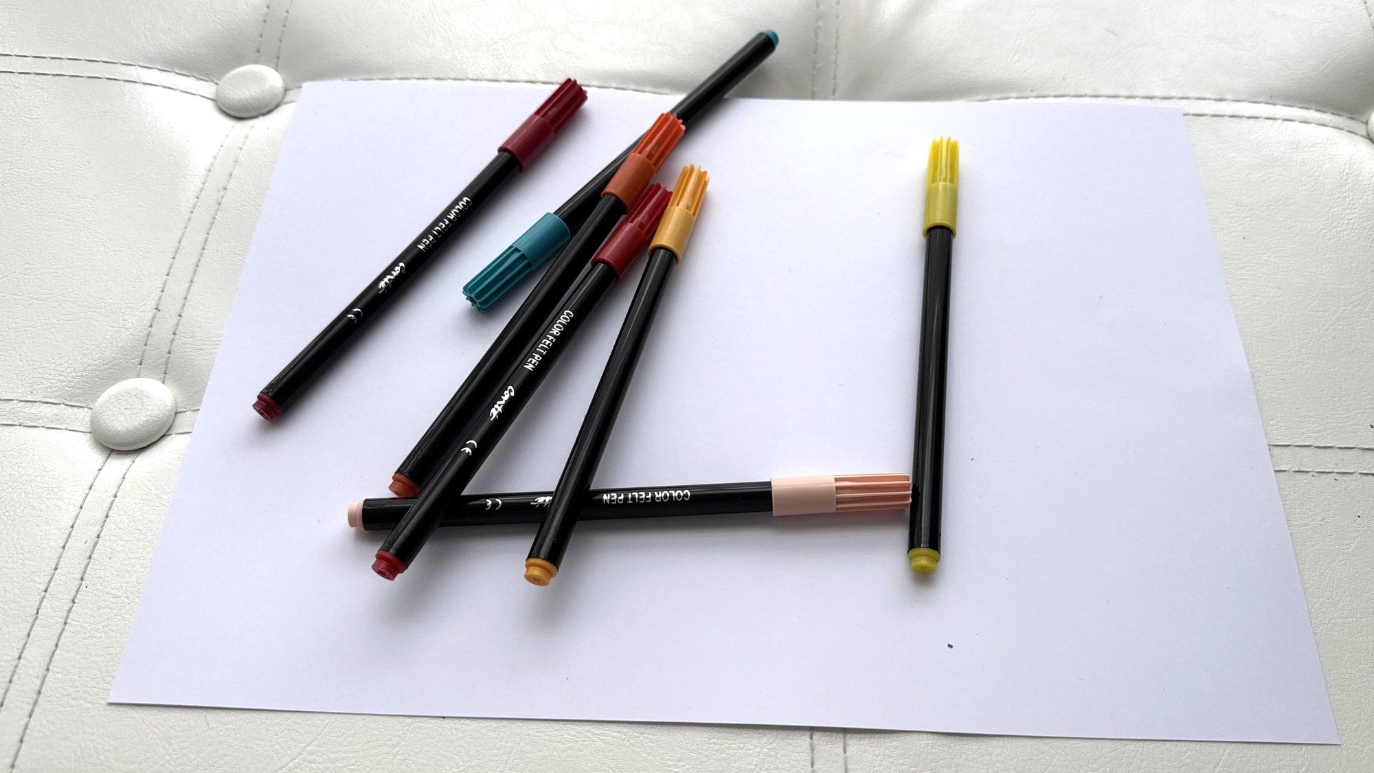 Des feutres de couleur éparpillés sur une feuille blanche